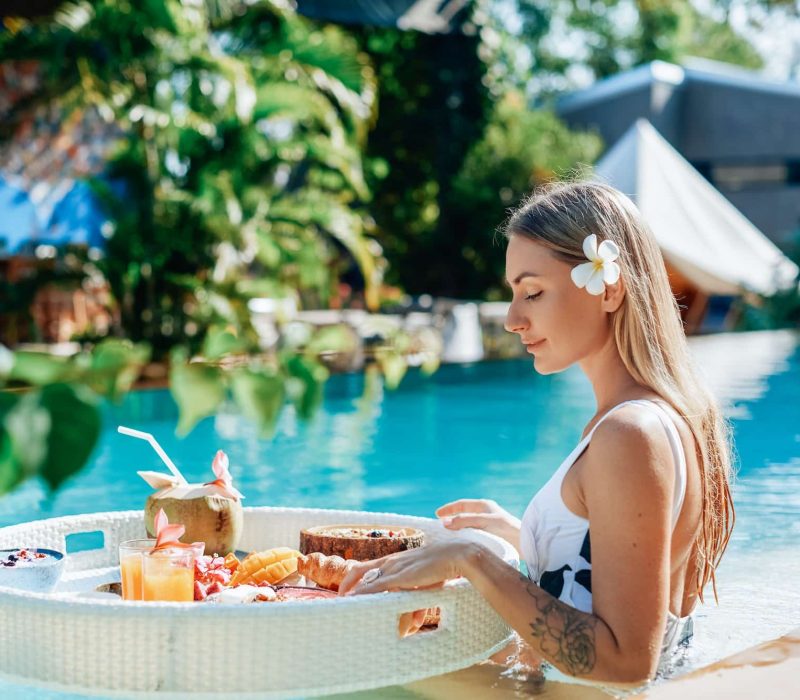 female-tourist-in-luxurious-hotel-enjoys-swimming-pool-and-tropical-food.jpg
